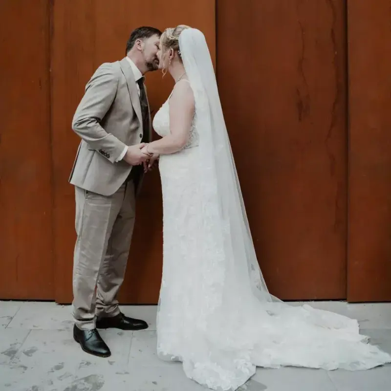 Couple kissing in front of a wooden door in Flensburg