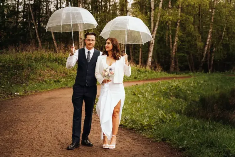 Couple with umbrellas on a forest path near Hamburg